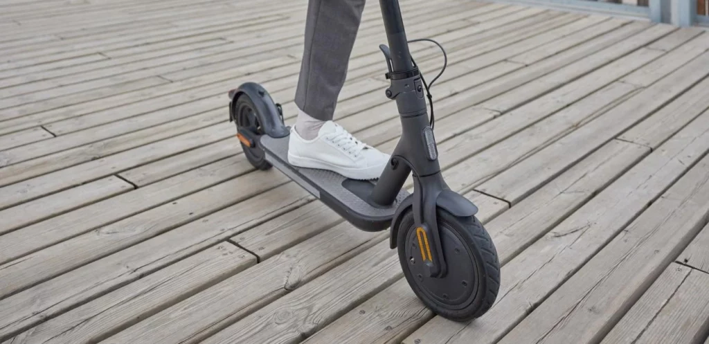 trottinette électrique vue de face sur un sol en bois.