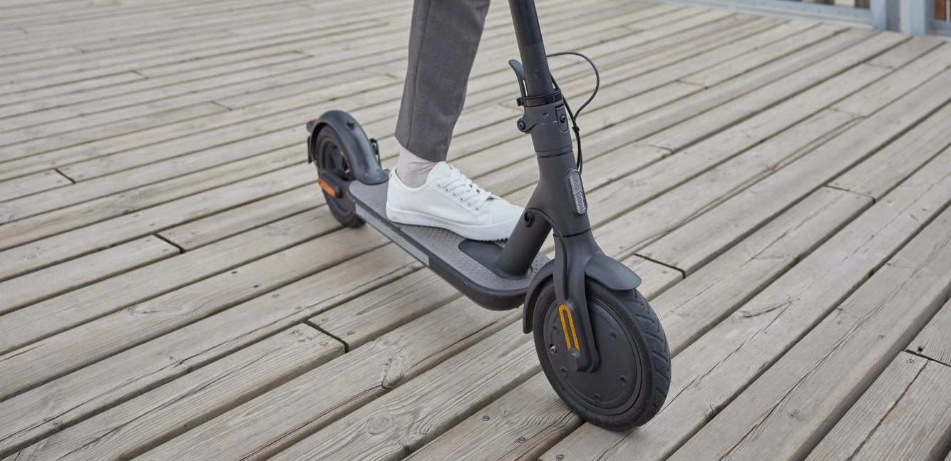 trottinette électrique vue de face sur un sol en bois.
